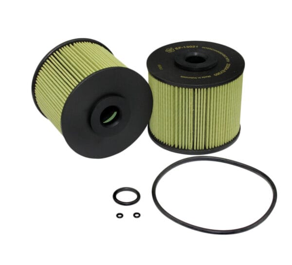 Two cylindrical oil filters with green pleated material and black caps are shown, accompanied by a large circular rubber gasket and two smaller rubber O-rings.