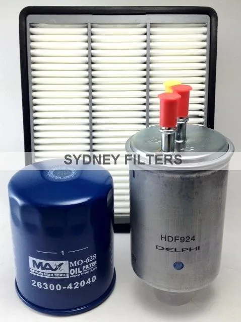 Three automotive filters are shown: a rectangular air filter in the background, a blue oil filter on the left, and a metal fuel filter on the right, labeled with "Sydney Filters.